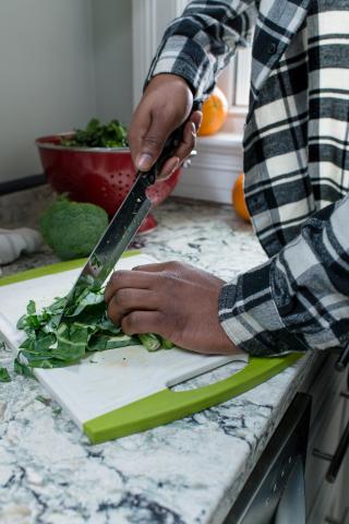 image tagged with broccoli, vegetables, knife, hands, cutting board, …;