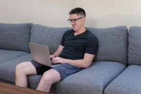image tagged with man, glasses, computer, sit, caucasian, …;