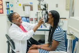 image tagged with smiling, eye exam, females, african-american, exam room, …;