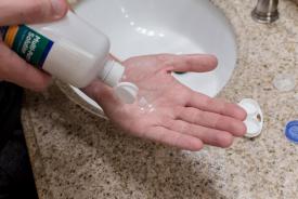 image tagged with wets, hand, cleaning solution, hold, cleans, …;