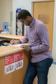 image tagged with standing, doctor's office, african-american, desk, doctor's appointment, …;