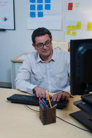 image tagged with glasses, man, workplace, looking, keyboard, …;