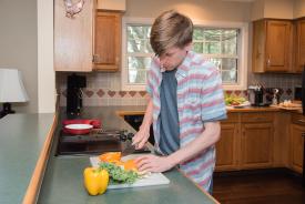 image tagged with chops, boy, food prep, kitchen, leafy greens, …;
