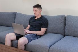 image tagged with sofa, boy, sits, computer, types, …;
