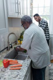 image tagged with vegetable, kitchen, people, stand, men, …;