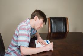 image tagged with writing, boy, table, notebook, guy, …;