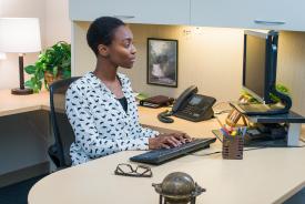 image tagged with lady, supplies, sits, african-american, office, …;