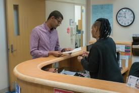 image tagged with check in, african-american, helping, doctor's office, adult, …;