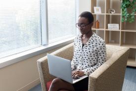 image tagged with female, african-american, sitting, laptop, sits, …;