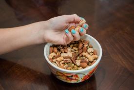 image tagged with holds, nuts, hand, eats, eat, …;