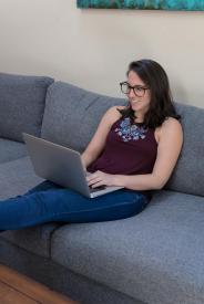 image tagged with sofa, female, sits, laptop, glasses, …;