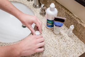 image tagged with restroom, cleaning solution, lens, hands, sink, …;