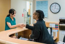 image tagged with smiles, african-american, doctor's office, hands, check-in, …;