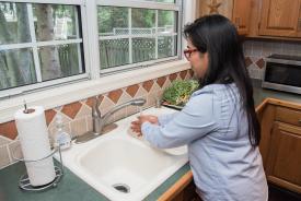 image tagged with glasses, paper towel, woman, sink, running water, …;