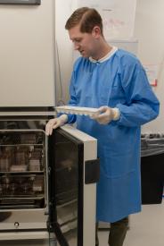 image tagged with holds, lab, open, tray, gloves, …;