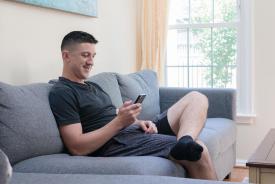 image tagged with sofa, boy, sits, phone, sit, …;