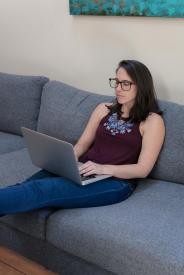 image tagged with couch, she, sit, looks, laptop, …;