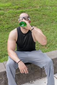 image tagged with sits, physical activity, drinks, field, bottle, …;