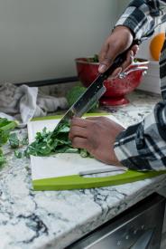 image tagged with cutting board, knife, african-american, vegetable, food prep, …;