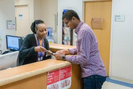 image tagged with nurse, man, paperwork, african-american, check-in, …;