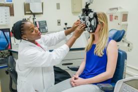 image tagged with exam room, african-american, eye exam, check-up, phoropter, …;