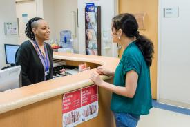 image tagged with african-american, helping, woman, check-in, doctor's office, …;