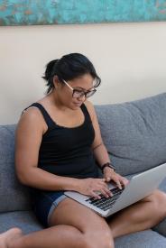 image tagged with sits, woman, asian-american, typing, laptop, …;