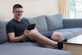 image tagged with looks, couch, smiling, man, screen, …;