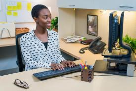 image tagged with female, smiling, workplace, keyboard, african-american, …;