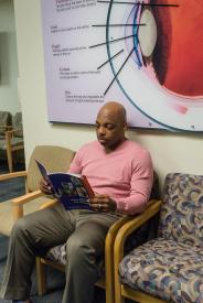 image tagged with african-american, reading, sits, hold, medicine, …;