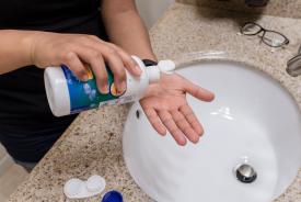 image tagged with holds, hands, cleaning solution, sink, solution, …;